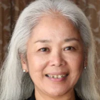 A woman with long white hair smiling for the camera.