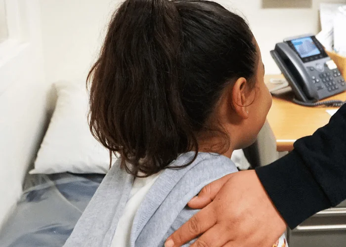 A young girl is being examined by a doctor in a hospital.