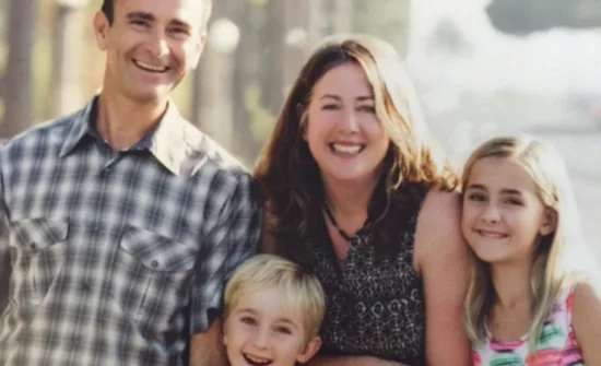 A family is posing for a picture in front of a street.